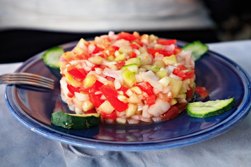 Fresh vegetables salad on the blue plate.