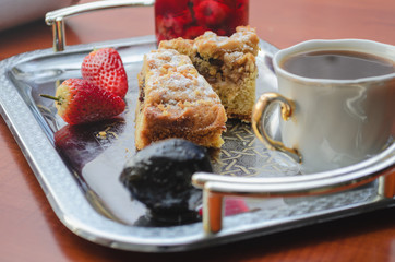 Hot coffee with cakes and strawberries. Dessert and Breakfast are on the tray.