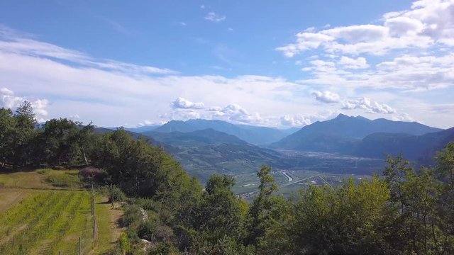 Cinematic Drone reveal of lush, green mountains in Trentino, Italy. View of Mezzocorona in the Rotaliana Plain