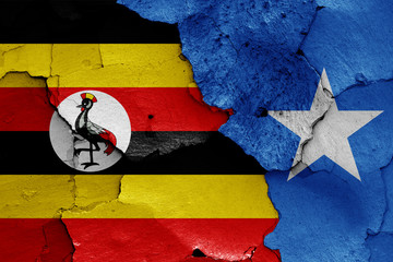 flags of Uganda and Somalia painted on cracked wall