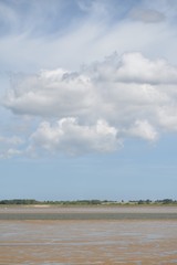 Obraz premium Cloudy skies over Breydon Water, a stretch of the River Yare in Great Yarmouth, Norfolk, UK.