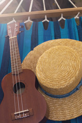 straw hat and ukulele on a hammock