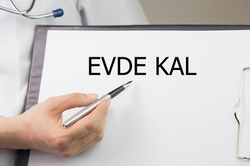 the word evde kal "stay at home in English" woman doctor shows stay at home 