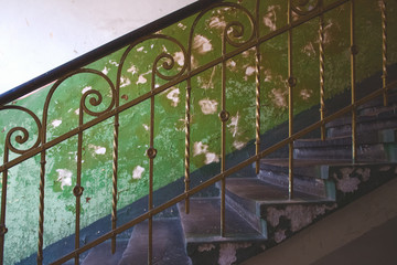 Classic vintage metal baluster against aged green wall in abandoned historical building in Lviv, Ukraine