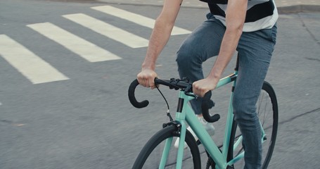 Young hipster man riding bike