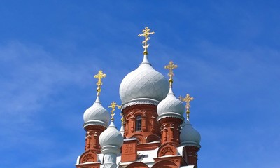 White domes and golden crosses of Orthodox Christian Church against blue sky background. Beautiful...