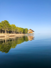 reflection of a wooden house on the lake, house on the river