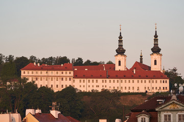 Fototapeta premium Landscape Picture of Strahov monastery in Prague, capitol of Czech republic taken during the spring sunrise in golden hour. It is a Premonstratensian abbey founded in year 1143 near to Prague castle.
