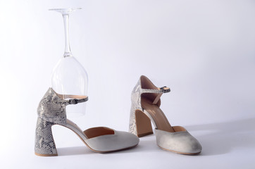 beige high-heeled shoes and a glass of wine. A glass of and women's shoes with heels.