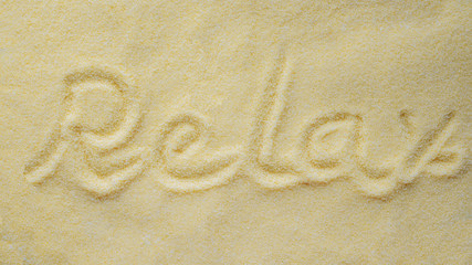 A yellow clean sand with written word relax.