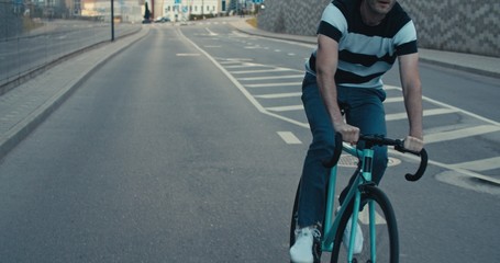 Naklejka premium Young hipster man riding bike