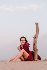 Silhouette of a girl in a red dress at sunset in the desert 