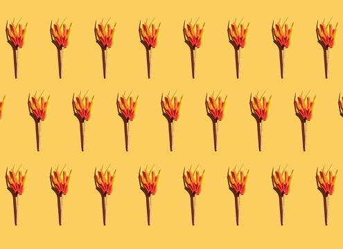Pattern of matches with cardboard flame against yellow background
