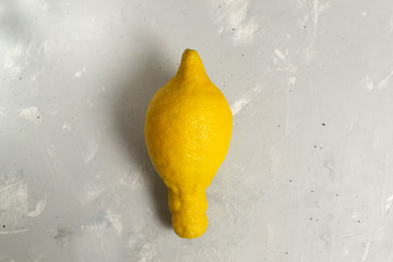 Ugly lemon on a gray background. Copy space. Close-up. Horizontal orientation. The concept of ugly...