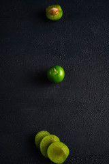 Green sour plum. Greengage on dark background.  Top view. Copy space for text message.