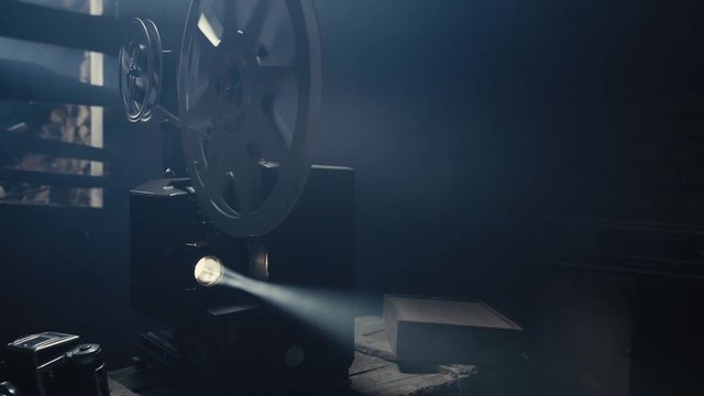 An Old Film Projector is a stock video that features beautiful footage of an old 16mm film projector projecting something in a haze.