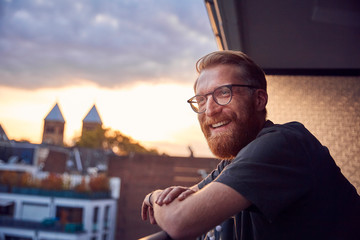 Portrait of relaxed man on balcony looking at distance