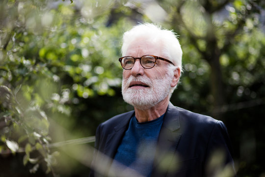 Portrait Of Bearded Senior Man With White Hair Looking At Distance