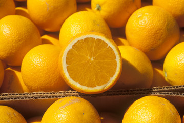 A halved orange rests on oranges in boxes in Ventura County ,CA