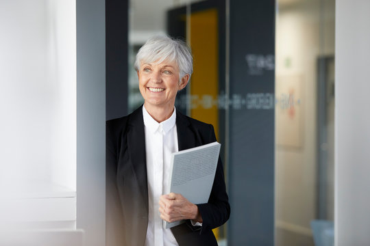 Portrait of smiling senior businesswoman looking at distance