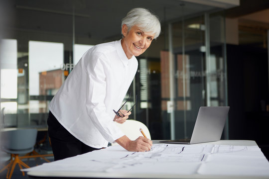 Portrait of architect working on construction plan in office
