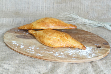 Uzbek samsa made of puff pastry with tasty filling on the kitchen board