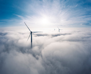 Germany, Aerial view of wind turbines shrouded in clouds at sunrise