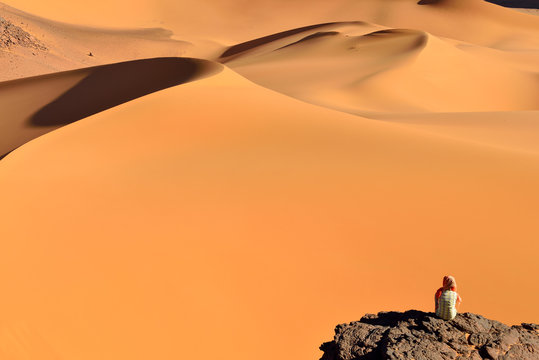 Algeria, Tassili n' Ajjer, Tadrart, Sahara, Tassili n' Ajjer National Park, woman looking to sand dunes of Moul Nag