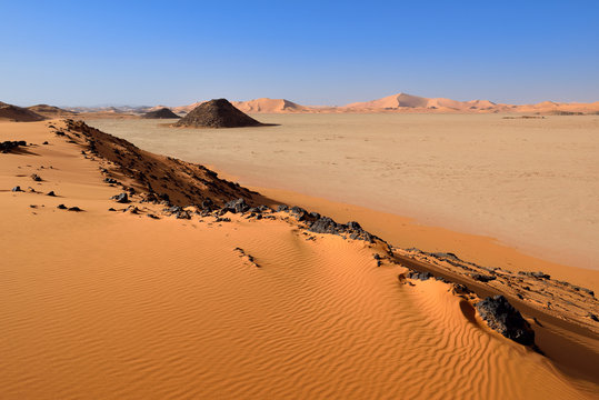 Africa, Algeria, Sahara, Tassili N'Ajjer National Park, Tadrart, Claypan and sand dunes at Oued in Djerane