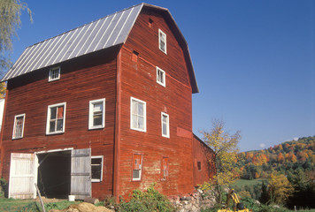 Fototapeta na wymiar A three story red barn in autumn in VT