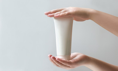 cosmetic product mockup. collagen mockup. woman holding a tube with cream or serum for skin and hair. tube for cosmetics with empty blank place for label text