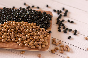 brown and black beans on wooden background