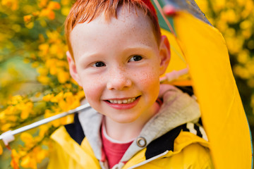 Portrait of redheaded little boy with umbrella