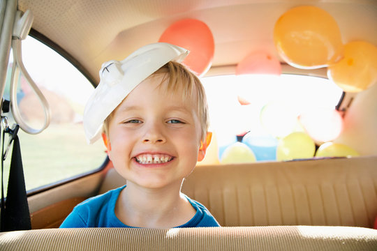 Germany, North Rhine Westphalia, Cologne, Portrait of boy in car with easter bunny mask, smiling