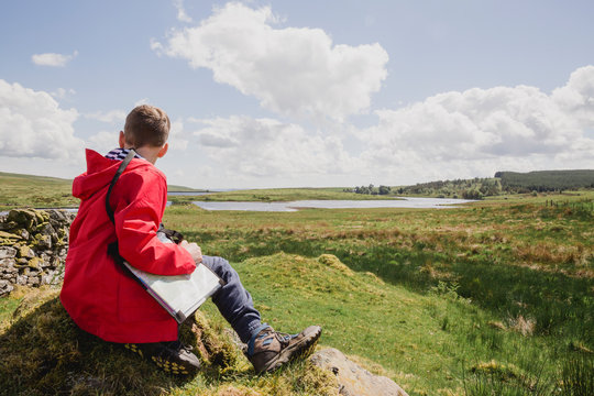 Boy with map looking at view, Cairngorms, Scotland, UK
