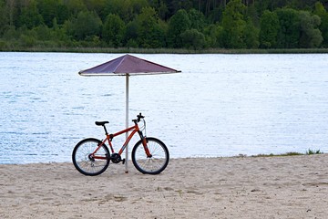 lonely bike near a lonely umbrella on the beach
