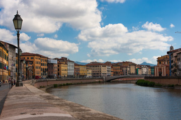Fototapeta premium The Arno River that runs alongside the houses of Pisa