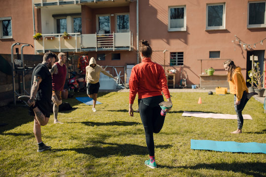 Group of friends doing workout together in garden