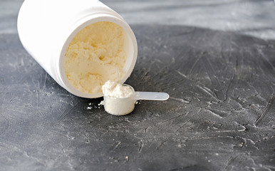 Collagen or protein in powder on grey background. protein powder for making whey drink or collagen peptides cocktail. 