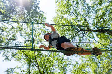 Boy on a high rope course in forest