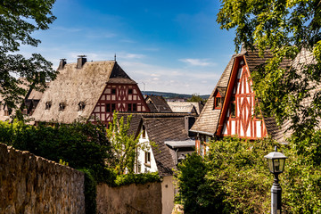 Limburg, Germany - 21st May 2020: A german photographer visiting the city, taking pictures of half-timbered houses at a sunny day in spring. - obrazy, fototapety, plakaty