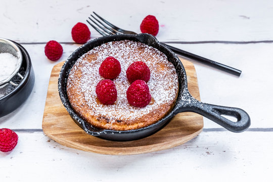 Dutch baby pancake with raspberries and powdered sugar