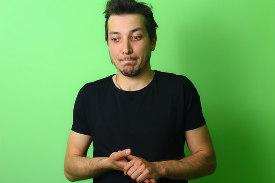 Young man or guy on a light green wall background. Emotion of Guilt and Forgiveness