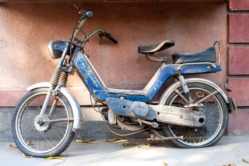 Obraz na płótnie Canvas Antigua motocicleta azul abandonada en la calle