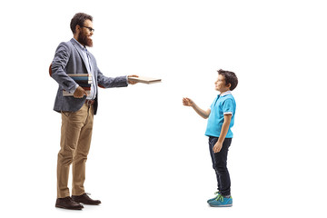 Fototapeta premium Bearded male teacher giving a book to a boy