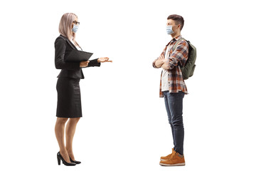 Fototapeta premium Businesswoman and a male student wearing a protective face masks and talking