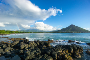 Rainbow over sea with blue sky and cloud