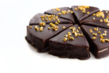 Slices of chocolate cake with green buckwheat on a white background. World Chocolate Day. Dessert without sugar close-up. Diet sweets. Treats for a holiday, birthday. Cook at home.