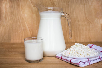 Tasty fresh milk on a white wooden background. A jug of milk and a glass of milk. copy space