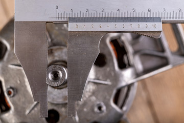 Measuring the thread with an analog caliper. Measurement work in the workshop.